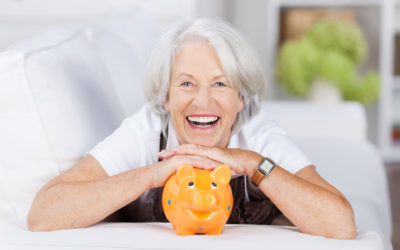 lachende seniorin mit ihrem sparschwein